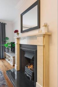 a fireplace with a mirror on top of it at GuestReady - Coastal Charm near Sandymount Beach in Dublin