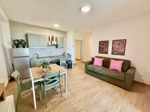 sala de estar con sofá y mesa con almohadas rosas en Suite dei Principi 1, aeroporto e parcheggio gratuito, en Bari