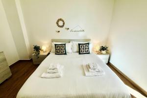 Un dormitorio con una gran cama blanca con toallas. en Suite dei Principi 1, aeroporto e parcheggio gratuito, en Bari