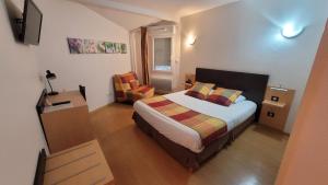 a bedroom with a bed and two chairs in it at Au P'tit Creux des Landes in Ychoux
