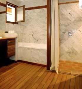 a bathroom with a tub and a sink and a shower at Hôtel La Gentilhommière in Nuits-Saint-Georges