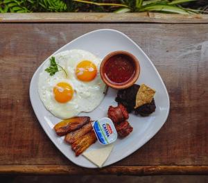 a plate of eggs and other breakfast foods on a table at Hotel y Restaurante Vista Verde in Santa Lucía Milpas Altas