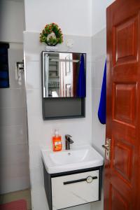 a bathroom with a sink and a mirror at Whitevillea Heights in Ruaka