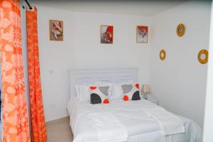 a bedroom with a bed with white sheets and pillows at Whitevillea Heights in Ruaka