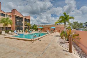 a pool at a resort with chairs and palm trees at Waterfront Views and Pool Access Punta Gorda Escape in Burnt Store Marina