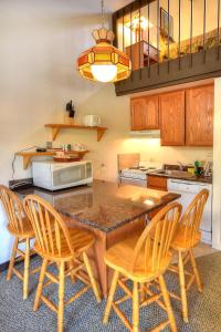 une cuisine avec une table avec des chaises et un micro-ondes dans l'établissement (A212) Loft Condominiums, à Yosemite West