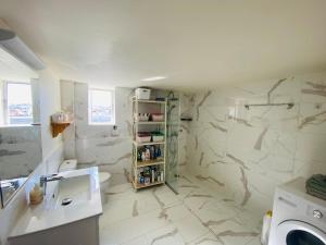 La salle de bains est pourvue de murs en marbre blanc et d'un lavabo. dans l'établissement Athens Wonderful Garden, 3 Bedrooms and 60sqm Super Terrace, à Athènes 50 autres photos