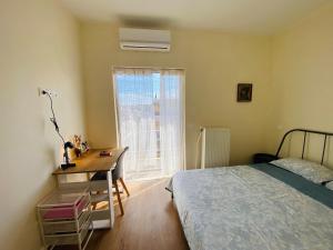 une chambre avec un lit, un bureau et une fenêtre dans l'établissement Athens Wonderful Garden, 3 Bedrooms and 60sqm Super Terrace, à Athènes