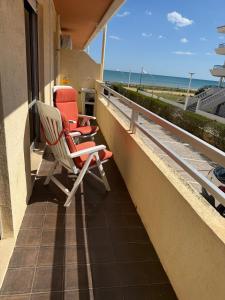 a balcony with two chairs and a view of the beach at Arenal-Inalko in Alcossebre +1 photo