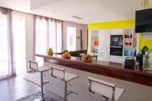 a kitchen with a bar with chairs and a counter at Villa Zaara in Sehib Foukani