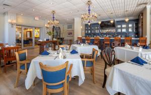 a restaurant with white tables and chairs and a bar at The GEM Museum Suites in Evanston
