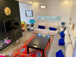 a living room with a couch and a tv at Villa Zaara in Sehib Foukani