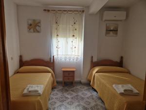 a room with two beds and a window at Rincón del Descanso in La Iruela +13 photos