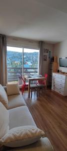 a living room with a table and a large window at studio Loubat pyrénée, ménage inclus in Arette