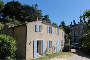 an old house with white shutters and a castle at L'Ombrière in Saint-Thomas-de-Cônac