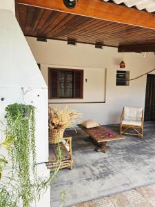 un patio al aire libre con banco y silla en Casa Central Ubatuba, en Ubatuba