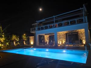 a villa with a swimming pool at night at Rastoni Studio Xylokastro 2 in Melission