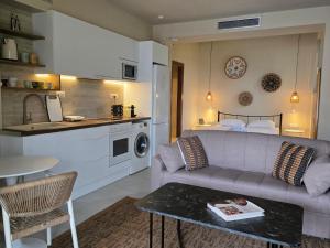 a living room with a couch and a kitchen at Rastoni Sea View Studio with Shared Pool in Melíssion