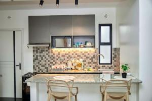 a kitchen with a counter and two chairs in it at Juwell Haven in Nairobi