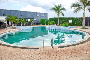 a large swimming pool with palm trees and a building at Juwell Haven in Nairobi