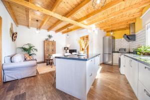 una cucina con mobili bianchi e soffitto in legno di El Refugio de la Caridad a Tenteniguada