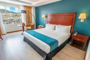 Una habitación de hotel con una cama grande y una ventana. en Sonesta Hotel Loja, en Loja