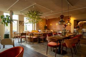 a restaurant with tables and chairs in a room at Strandstudio's Camperduin in Schoorl