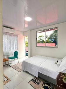 Un dormitorio con una cama y una mesa y una ventana. en amanecer entre trinos y alas, en San José del Guaviare