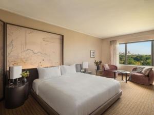 a hotel room with a large bed and a large window at Hotel Loft Near IGI Airport Delhi in New Delhi