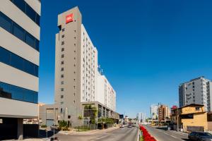 a tall white building on a city street at ibis Navegantes Itajai in Itajaí