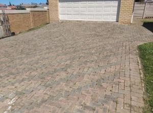 a brick driveway in front of a garage at House 38 in Beacon Bay