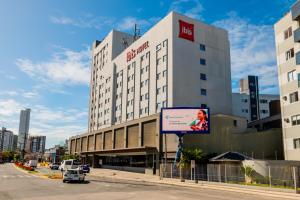 un gran edificio con una valla delante en ibis Navegantes Itajai, en Itajaí