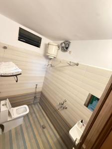 ein Badezimmer mit Toilette, Waschbecken und Spiegel in der Unterkunft Emaar Homestays in Hyderabad + 60 Fotos