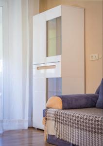 ein weißer Schrank in einem Zimmer mit einem Sofa in der Unterkunft Солнечный 1 кв Еврик in Dnipro