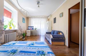 ein Wohnzimmer mit einem großen Bett und einem Sofa in der Unterkunft Солнечный 1 кв Еврик in Dnipro