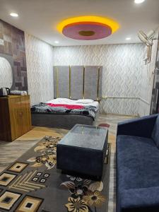a living room with a bed and a couch at Hotel Parinay Vatika - Deoghar in Deoghar +1 photo