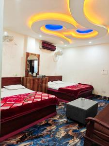 een kamer met twee bedden en een plafond met een schilderij bij Hotel Parinay Vatika - Deoghar in Deoghar