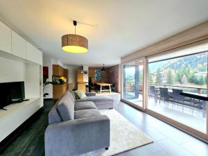 a living room with a couch and a large window at Champex Art Lodge in Orsières