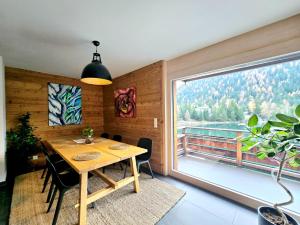 a dining room with a table and a large window at Champex Art Lodge in Orsières