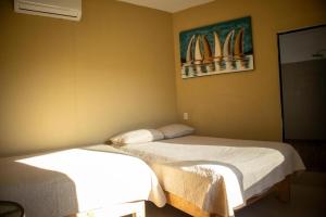 two beds in a room with surfboards on the wall at Vista Sayulita in Sayulita