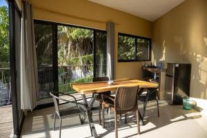 a dining room with a table and chairs and windows at Vista Sayulita in Sayulita