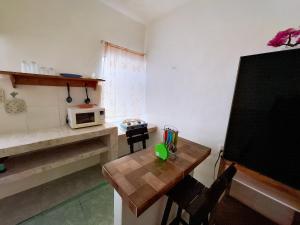 Habitación pequeña con mesa y microondas. en Casa Jedidian, en El Cuyo 2 fotos más