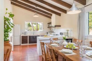 a kitchen and dining room with a wooden table and chairs at Los Olivos - Casa rural en exclusiva finca privada in Sant Lluis