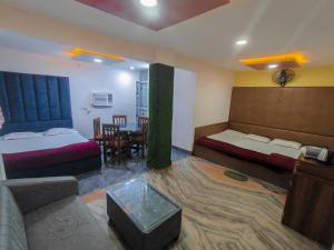 a hotel room with two beds and a table at Hotel Parinay Vatika - Deoghar in Deoghar +10 photos