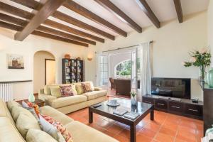 a living room with a couch and a tv at Los Olivos - Casa rural en exclusiva finca privada in Sant Lluis