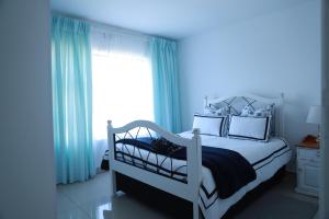 Un dormitorio con una cama blanca y una ventana. en Croydon Cove, en Port Alfred