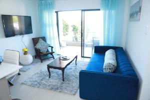Una sala de estar con un sofá azul y una mesa. en Croydon Cove, en Port Alfred