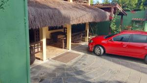 a red car parked in front of a building at Pousada La Floratta in Paulista