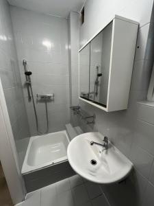 a white bathroom with a sink and a shower at Home15 Kassel in Kassel