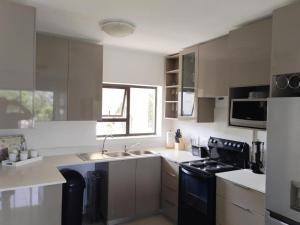 a kitchen with a sink and a stove top oven at Croydon Cove in Port Alfred
